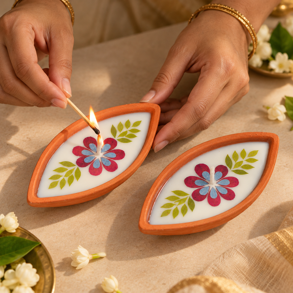 Boat-Shaped Pressed-Flower Terracotta Diyas, being lit by hand